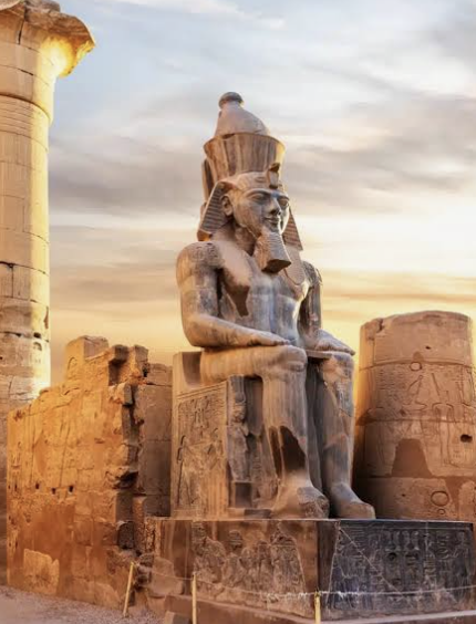 Ancient Egyptian statue and temple architecture in warm evening light